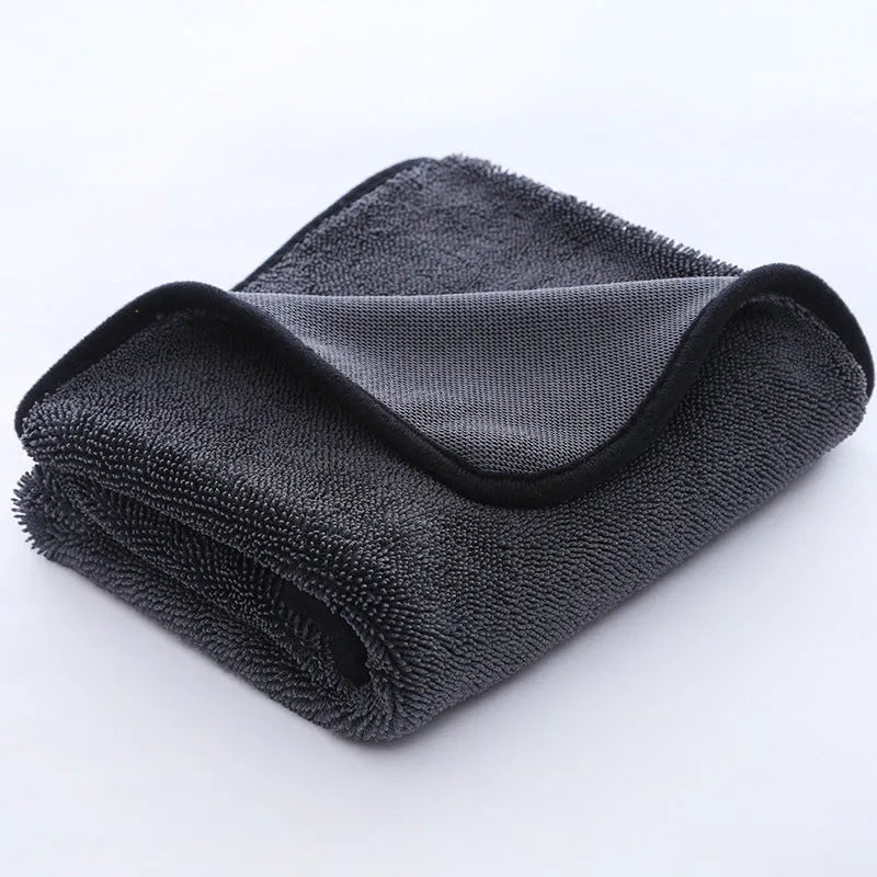 Grey automobile cleaning cloth with black edging showing spiral hair texture and hemmed edges