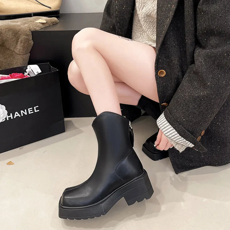 Black platform Martin ankle boots for women with a square toe and back zipper on a white background.