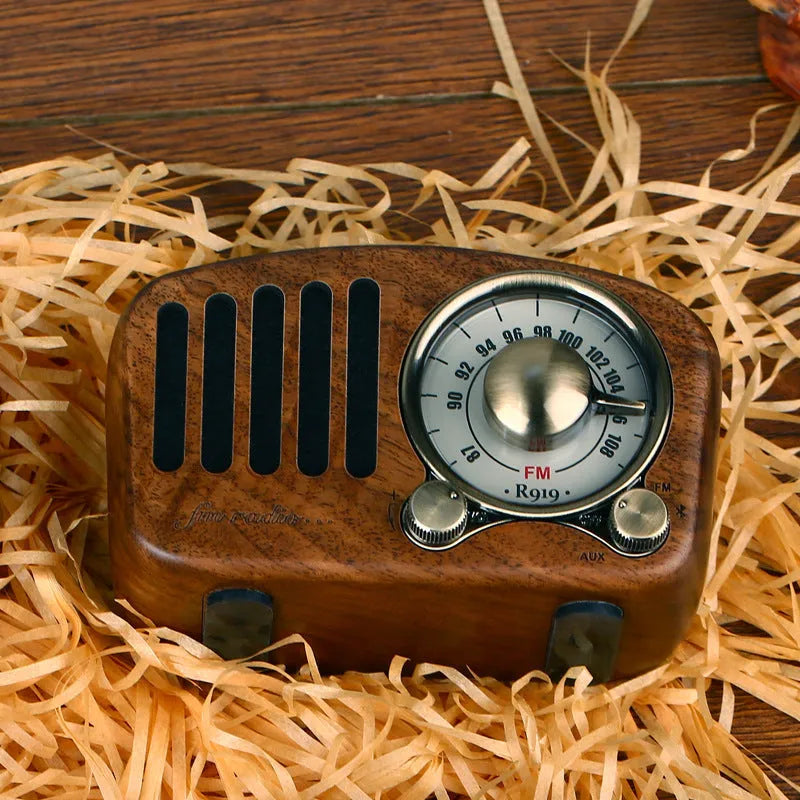 Retro wooden mini Bluetooth speaker in cherry wood finish on a table.