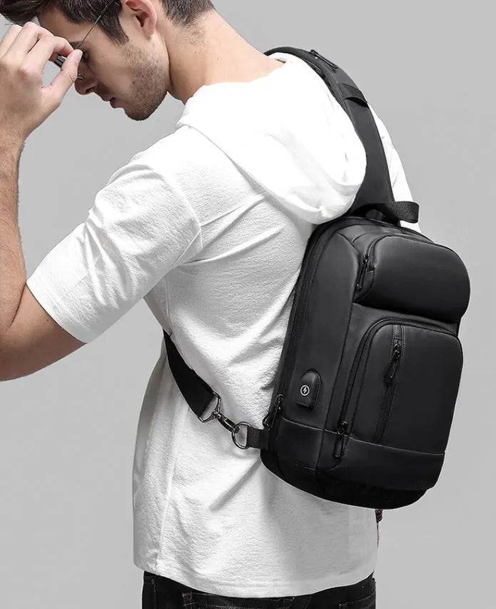 Black PVC outdoor shoulder bag with air cushion strap, soft handle, and laptop compartment
