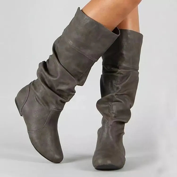 Women's flat ankle boots in black with a round toe, slip-on design, and high cylinder cut.