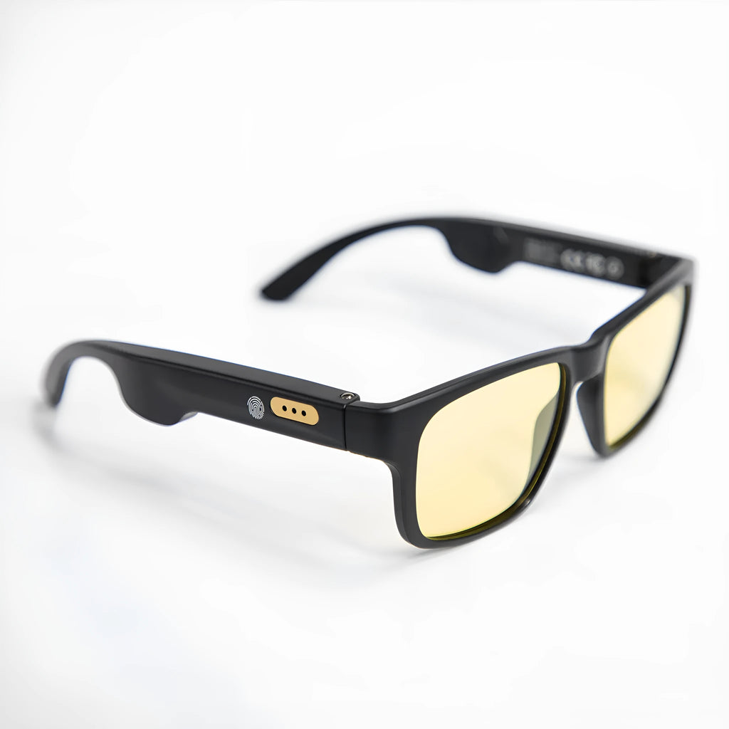 Smart Bluetooth sunglasses with black frame and stereo speakers on a table