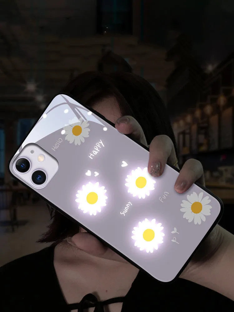 White voice-activated LED iPhone case with painted daisy and letter design, showing colour-changing lights.