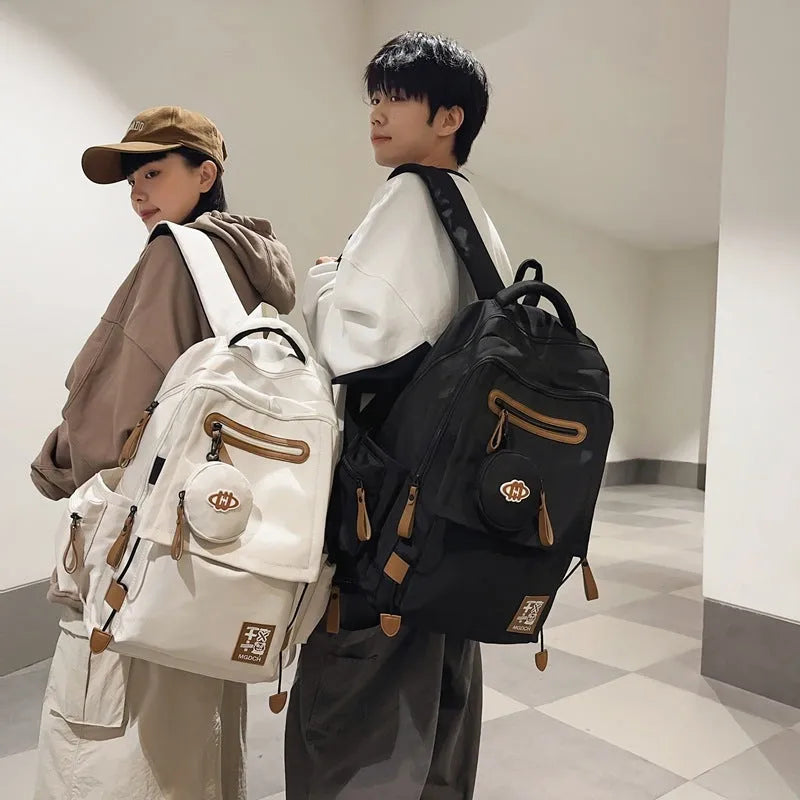 Large black nylon school backpack with curved shoulder straps, shown in a street style design for students.