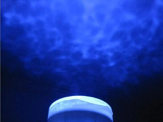 Blue coloured ocean wave light projector with DLP technology on a surface.