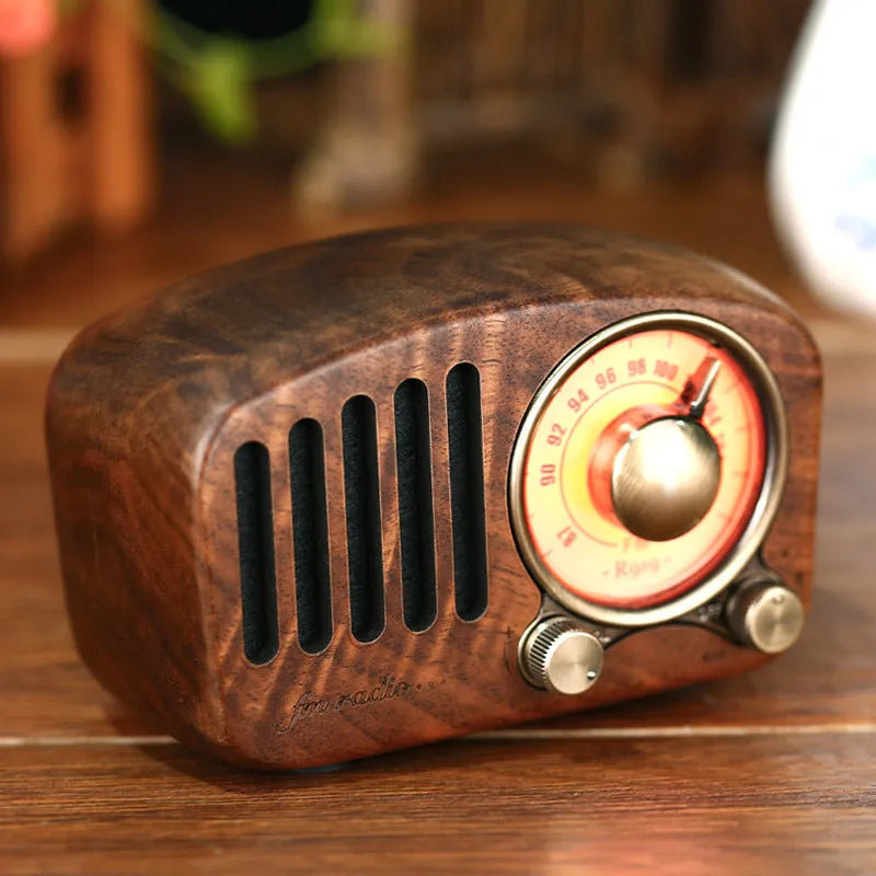 Retro wooden mini Bluetooth speaker in cherry wood finish on a table.