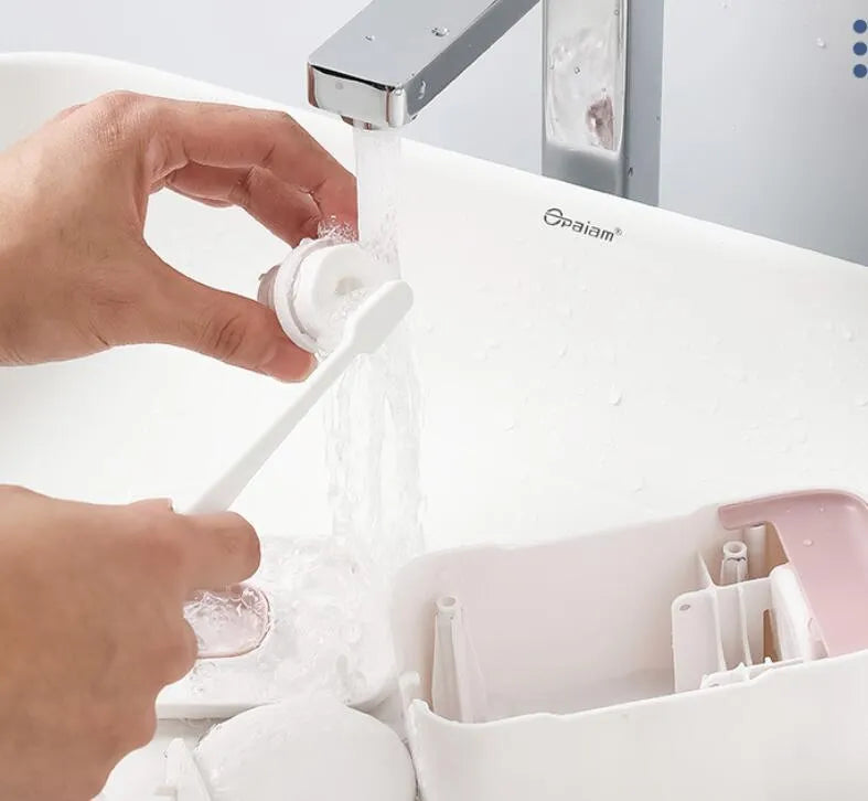 Automatic toothpaste dispenser in ABS plastic with suction cup wall mount in blue, grey, and pink colour options