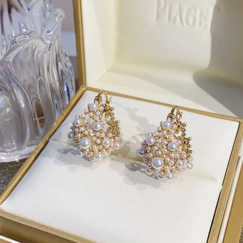 Gold-coloured copper flower basket earrings with rice-shaped bead inlay detail