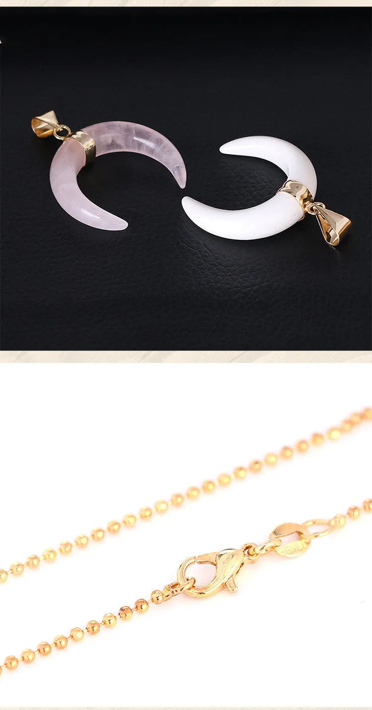 A moon-shaped pendant necklace with a pink natural stone on a copper-coloured chain against a white background.