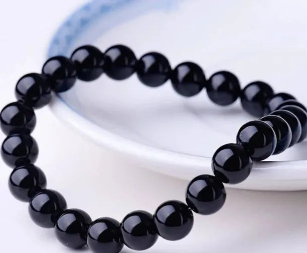 Women's black onyx bead bracelet with geometric design on a stretchy elastic cord.