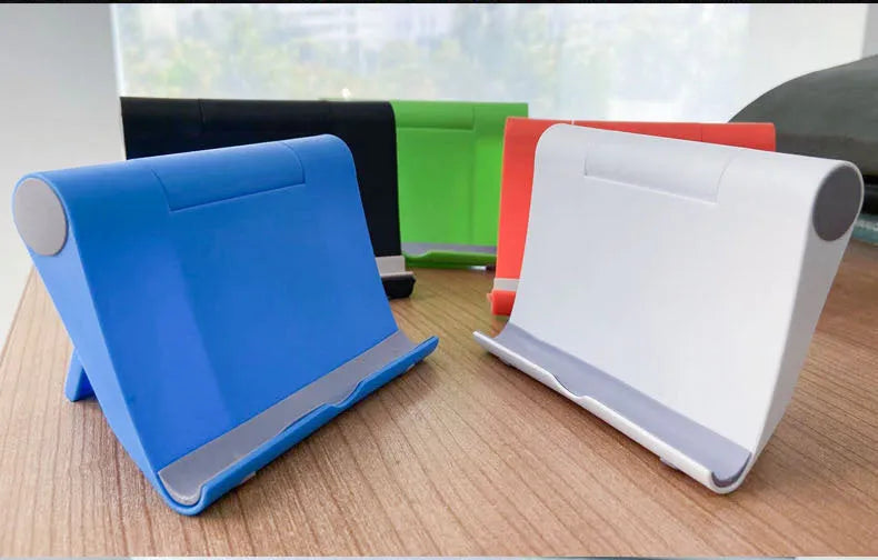 Black PE folding stand holding a mobile phone at an angle on a wooden desk.