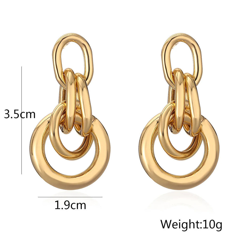 Geometric gold-colour drop earrings with irregular details and high-profile construction