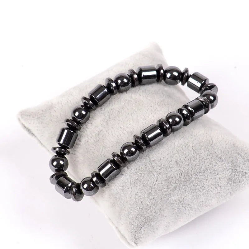 Black pentagram stone magnetic therapy bracelet with stretch fit on a wrist.