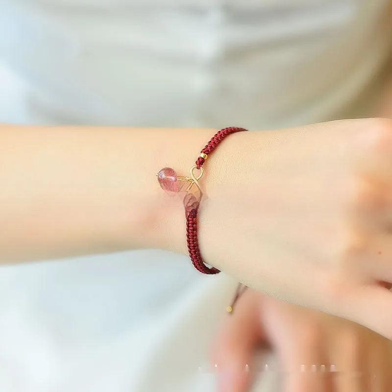 Women's natural strawberry quartz crystal bracelet with red cherry-shaped beads on a string.
