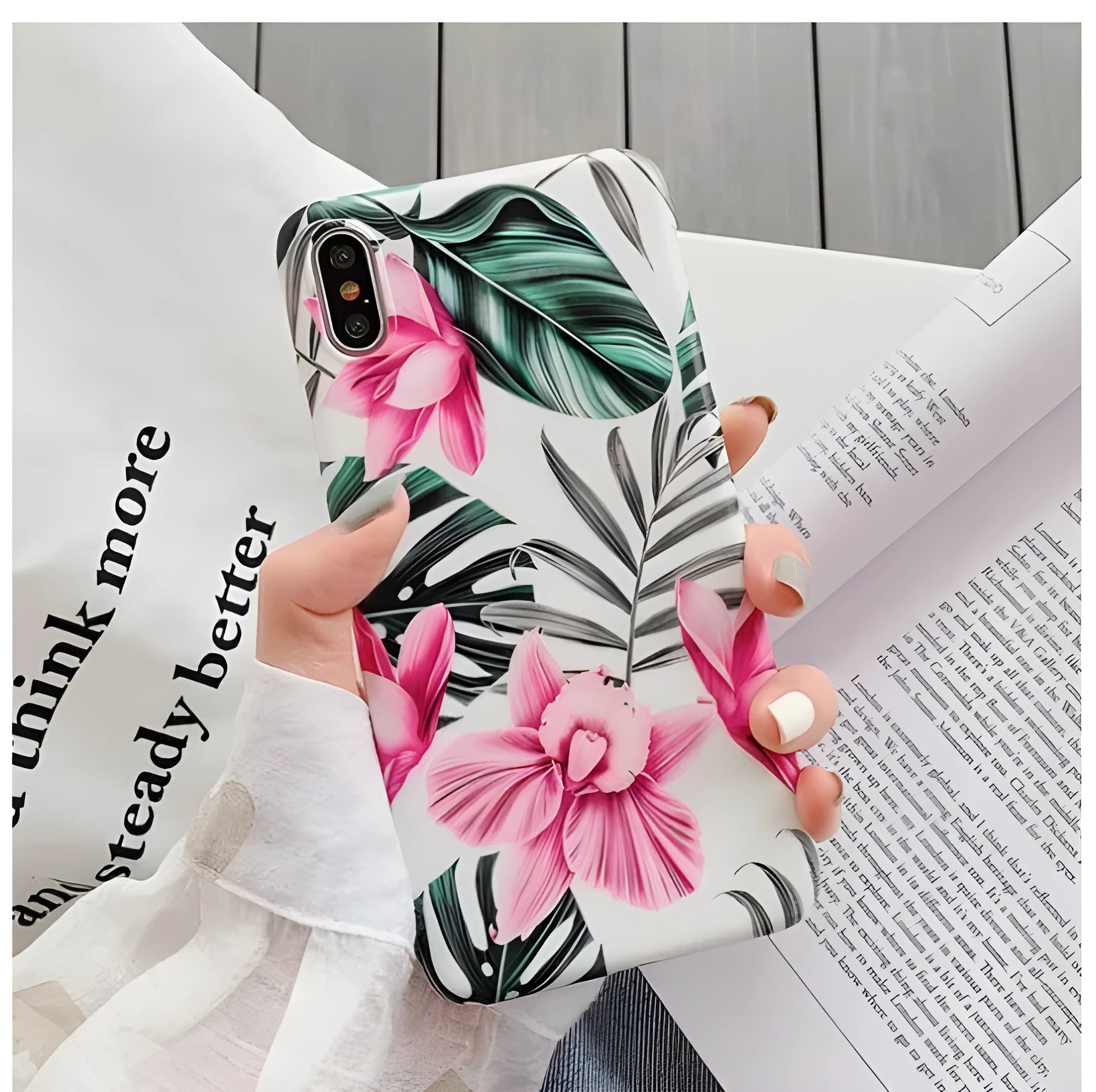 Pink floral patterned TPU back cover case for iPhone on a table.
