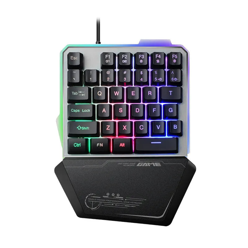 Black one-handed robotic gaming keyboard with RGB backlit keys on a desk.