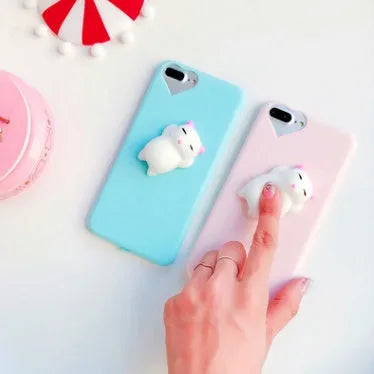 Soft silicone iPhone case with a raised 3D cartoon cat design, shown in pink.