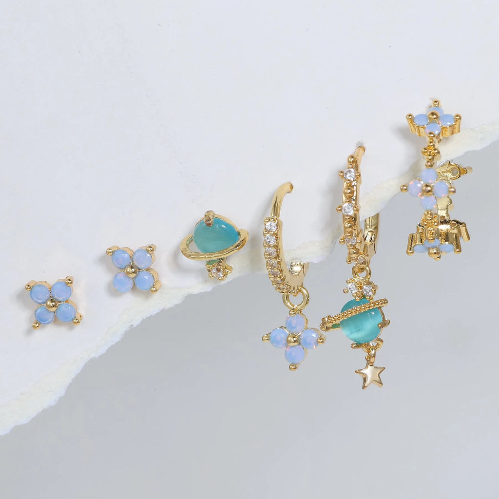 Gold and silver flower shaped stud earrings with zircon mosaic accents on white background
