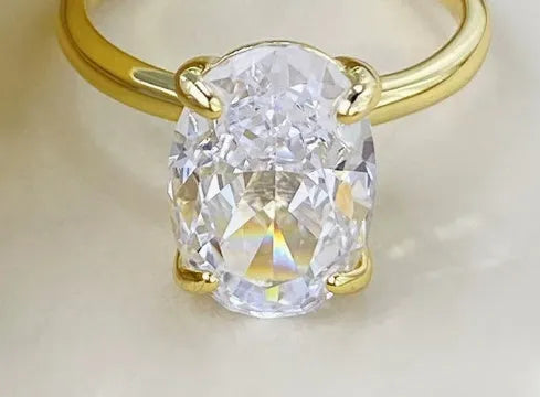 Oval women's ring in silver with four-claw setting holding a hand-cut gem.
