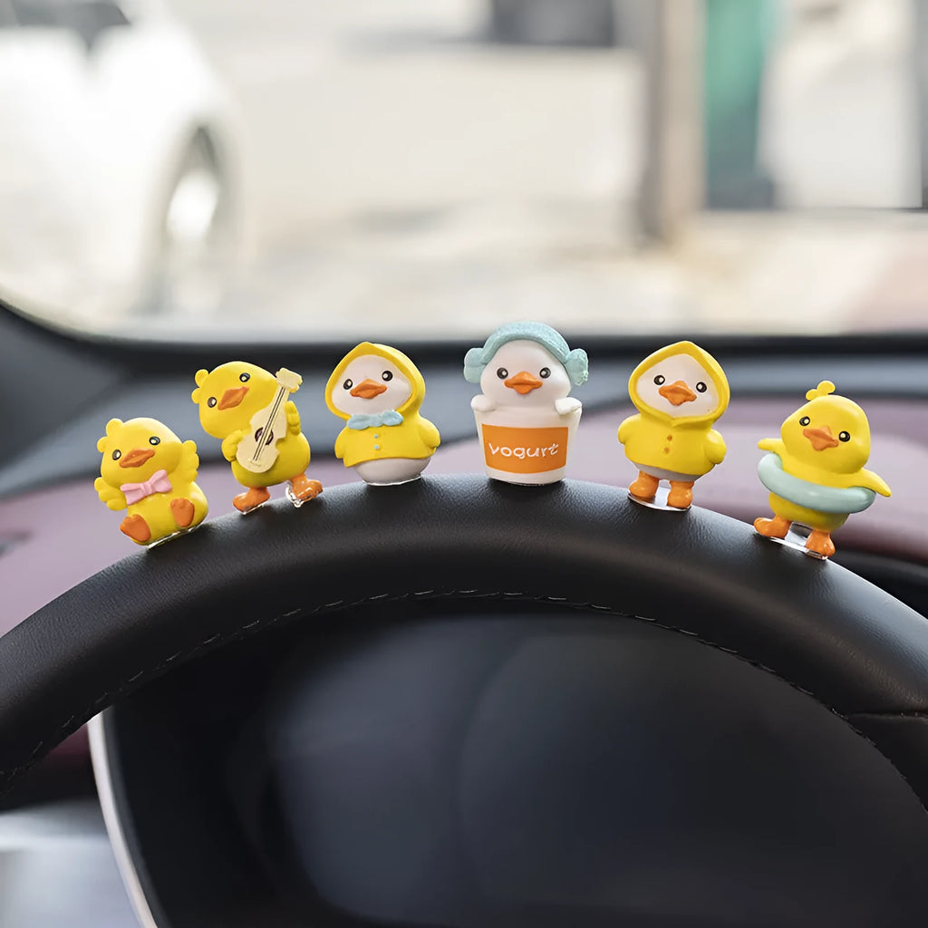 Yellow PVC cartoon duckling car decoration set with six ducks and a Hello sign on a car dashboard.