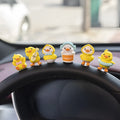 Yellow PVC cartoon duckling car decoration set with six ducks and a Hello sign on a car dashboard.