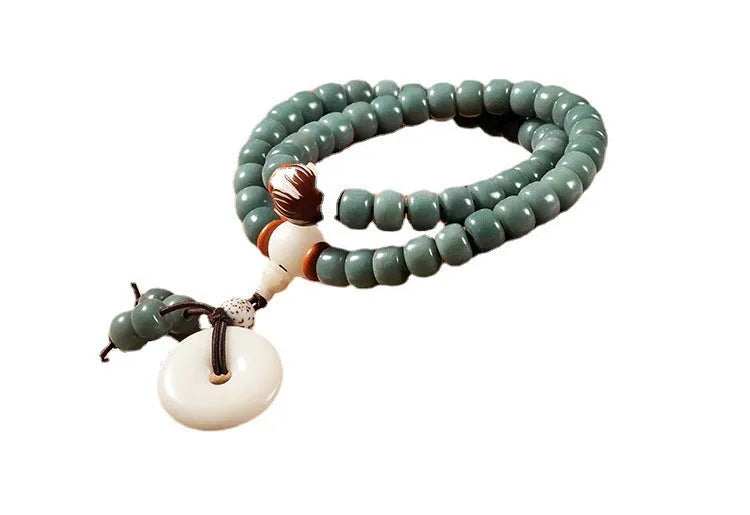 White jade and green sandalwood Bodhi seed bracelet with double ring safety buckle and lotus design.
