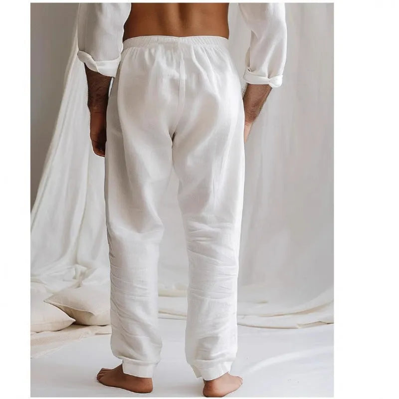 Man wearing light grey cotton-linen summer trousers with an elastic waist and straight leg fit.