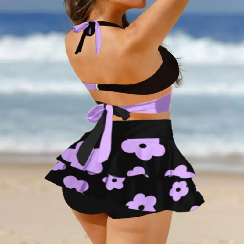 Purple women's bikini with lace-up front and matching high-waisted split skirt.