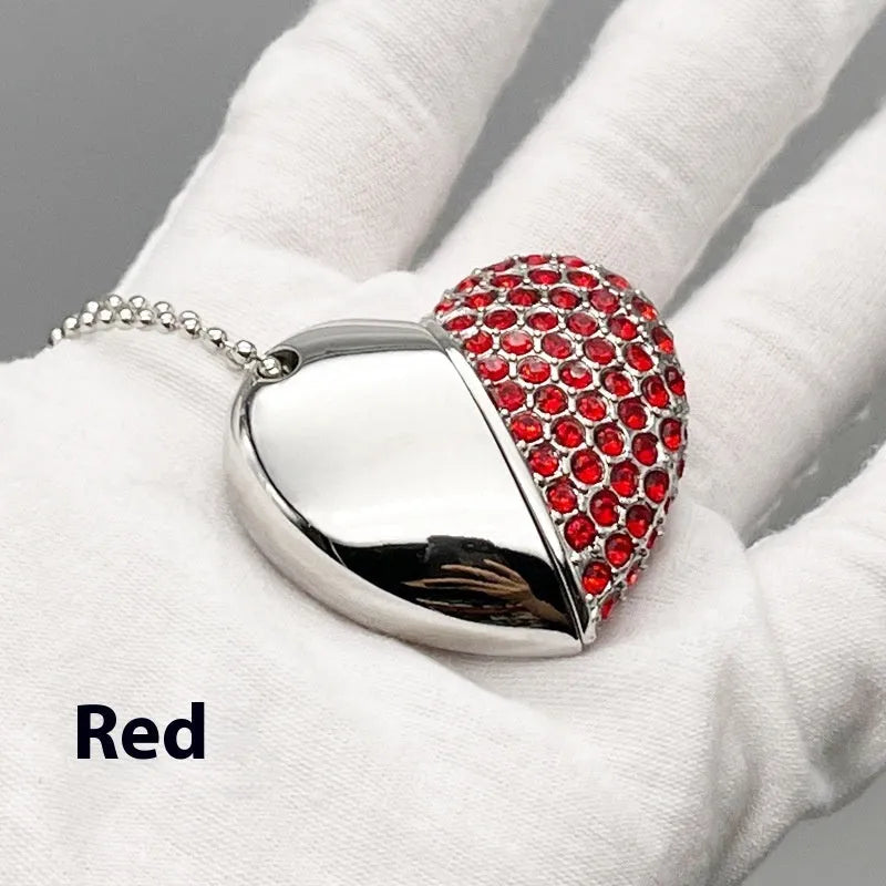 Heart-shaped silver USB drive with brick-like pattern, shown alongside blue and pink coloured versions.
