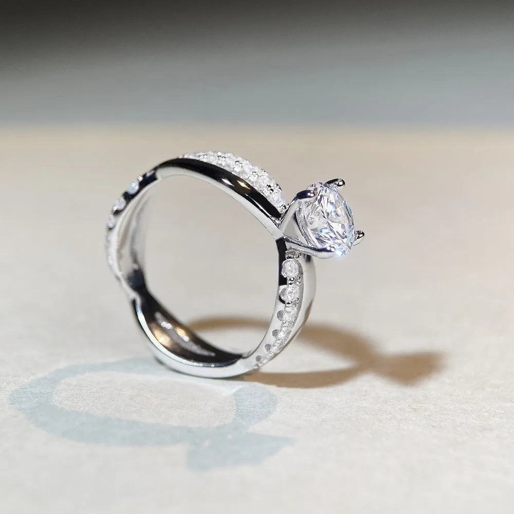 Geometric silver ring with twisted band and a 1 karat moissanite stone in a four-claw setting.