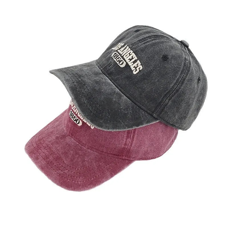 Retro distressed peaked cap with embroidered letters and adjustable strap in multiple colour options