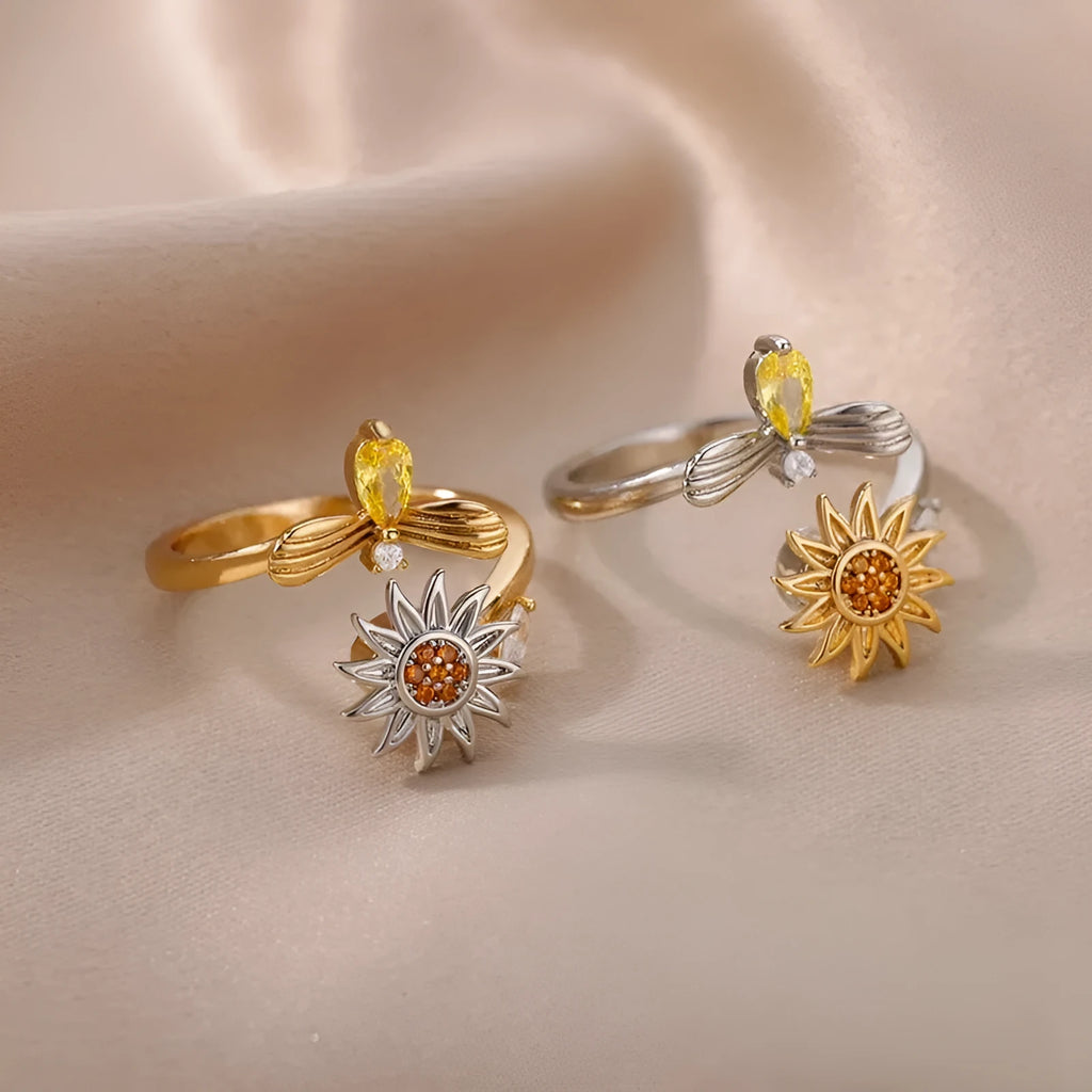 Gold and platinum coloured adjustable geometric decompression ring with rotatable element on a white background.