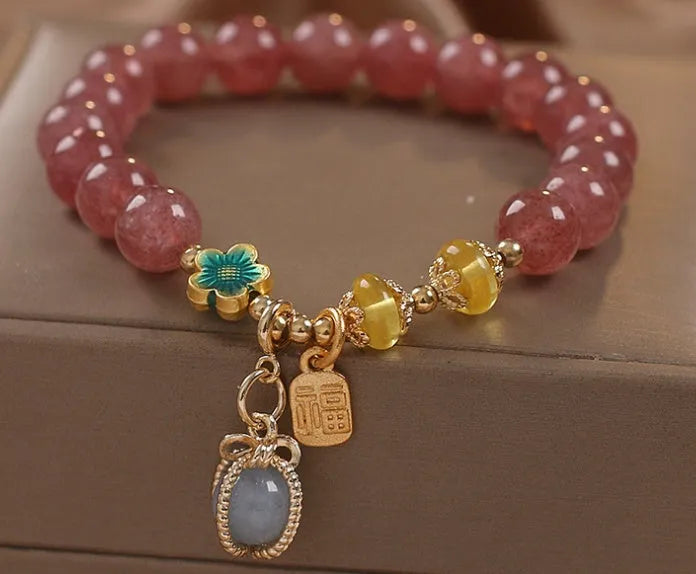 Red women's bracelet with natural strawberry quartz beads, alloy metal chain, and rhinestone details.