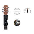 Black automatic guitar chord practice device for novice players on a folk guitar.