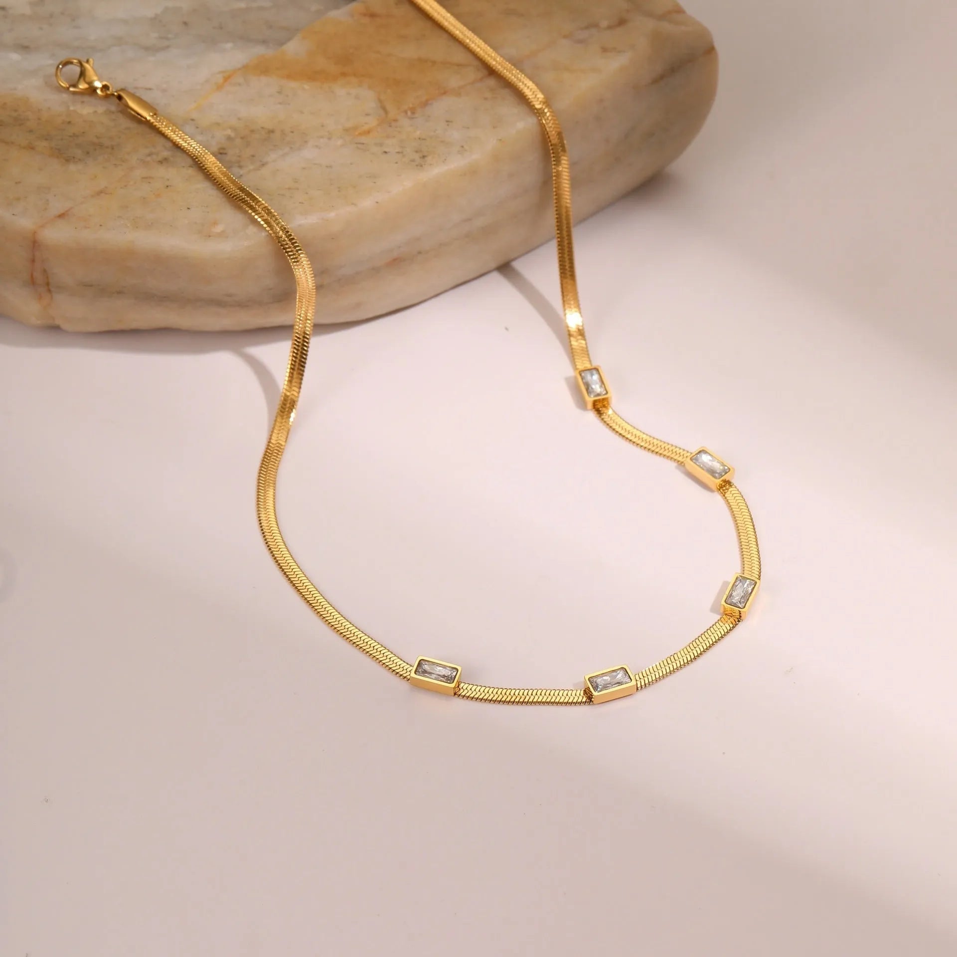 Geometric square zircon pendant on a stainless steel flat snake chain necklace.