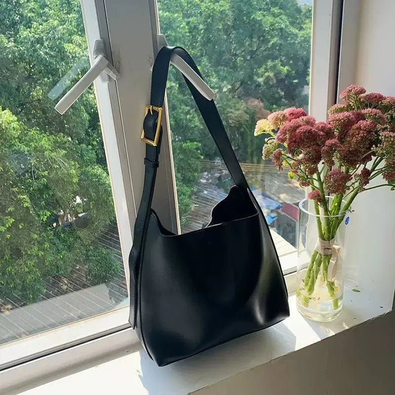 Two women's fashion shoulder bags in black and brown PU leather with swing thread details