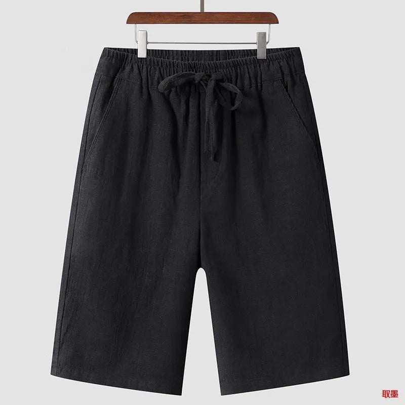 Man wearing beige linen casual shorts with a loose, cropped fit and elasticated mid waist.