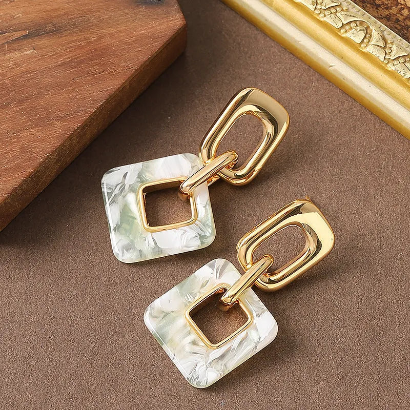 Pair of hollow geometric square copper earrings with chamfered corners in silver tone finish.