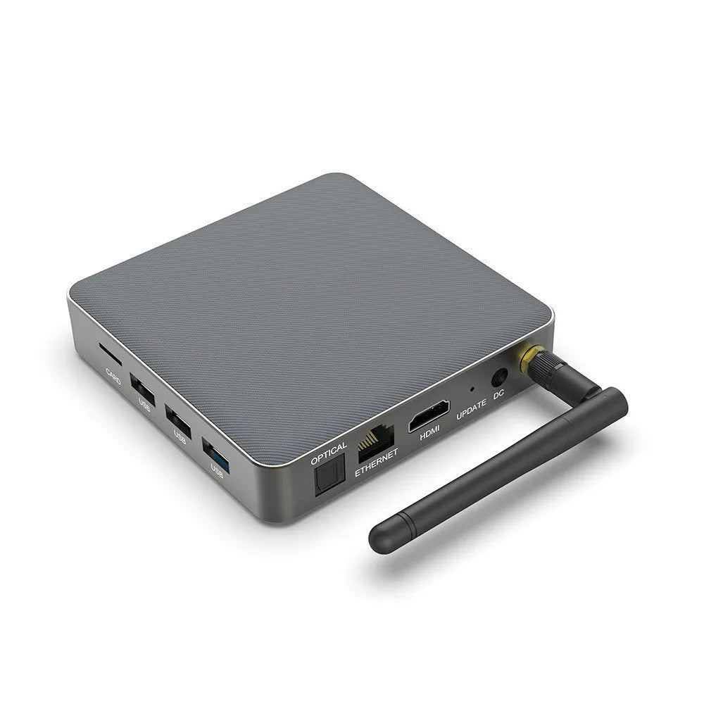 Black Android 8K set-top box with remote control, HDMI cable, and UK plug on a wooden surface.