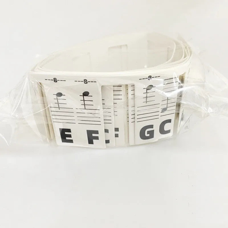 Set of white cardboard piano keyboard stickers showing colour note bars and black letter labels for 88 keys.