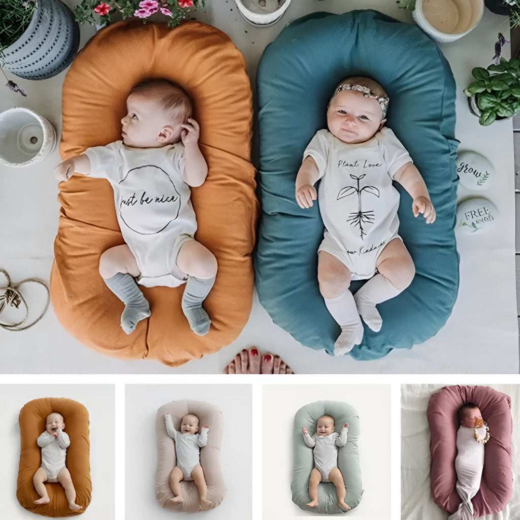Beige portable baby nest crib cushion measuring 75cm by 45cm on a neutral background