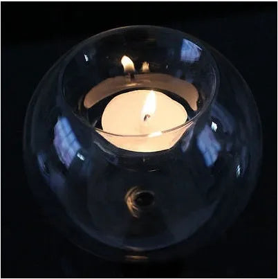 Clear handmade round hollow glass candleholder on a table.