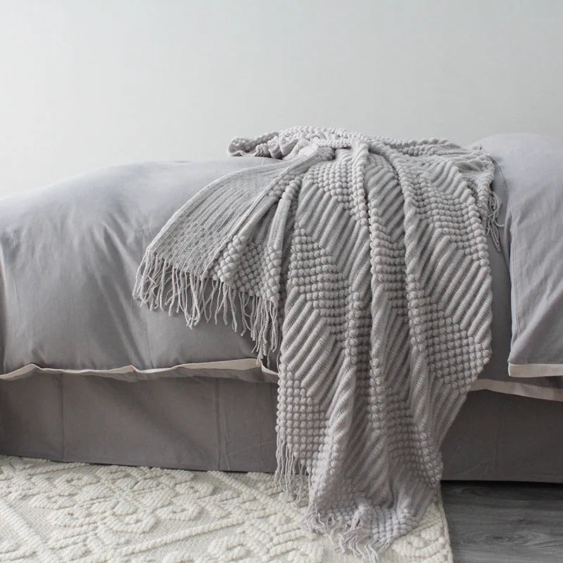 Small grey polyester blanket folded, dimensions 127 by 170 centimetres.