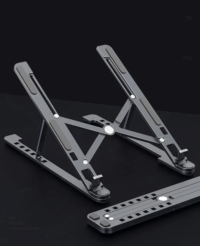 Silver foldable aluminium laptop stand holding a MacBook at an adjustable angle.