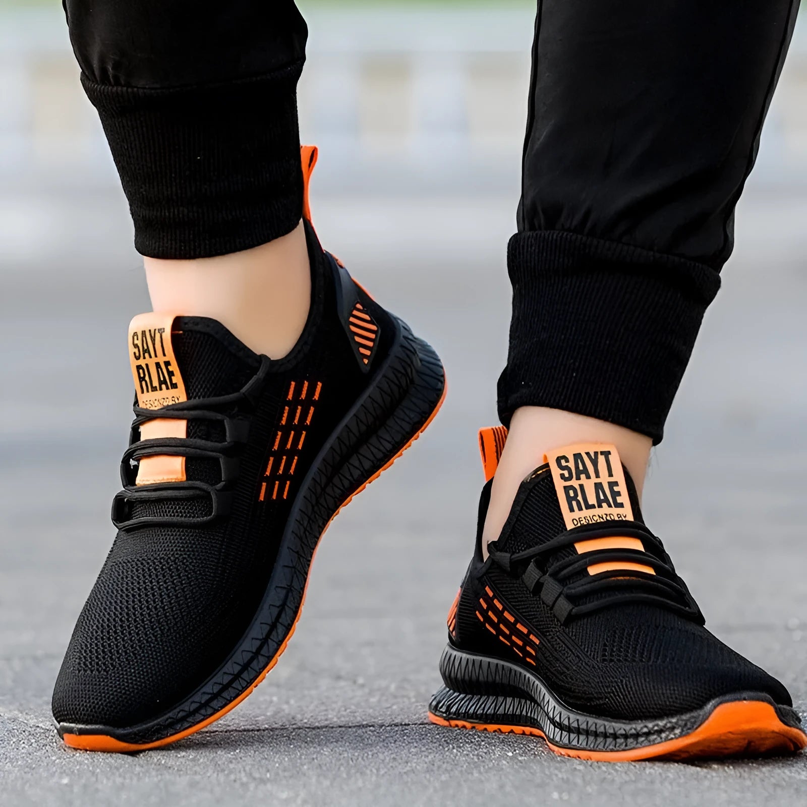 Men's low-top casual sports shoes with cross strap detail over a Flying Weave upper in black, orange, or yellow.