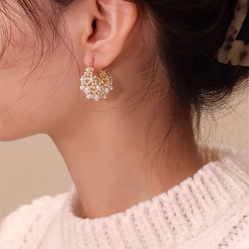 Gold-coloured copper flower basket earrings with rice-shaped bead inlay detail