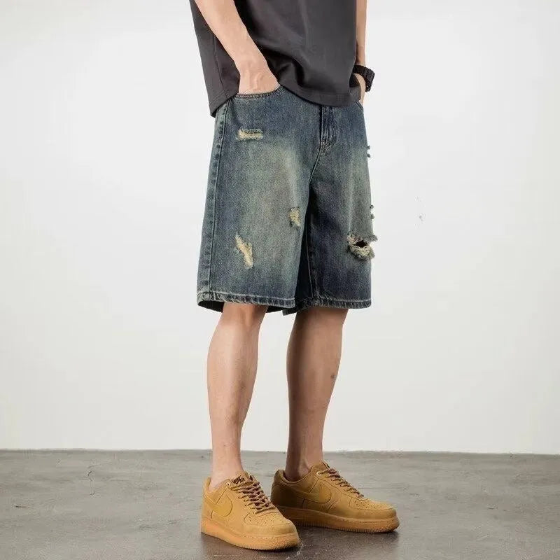 Men's blue denim shorts with retro loose hole distressing and a straight-leg cut.