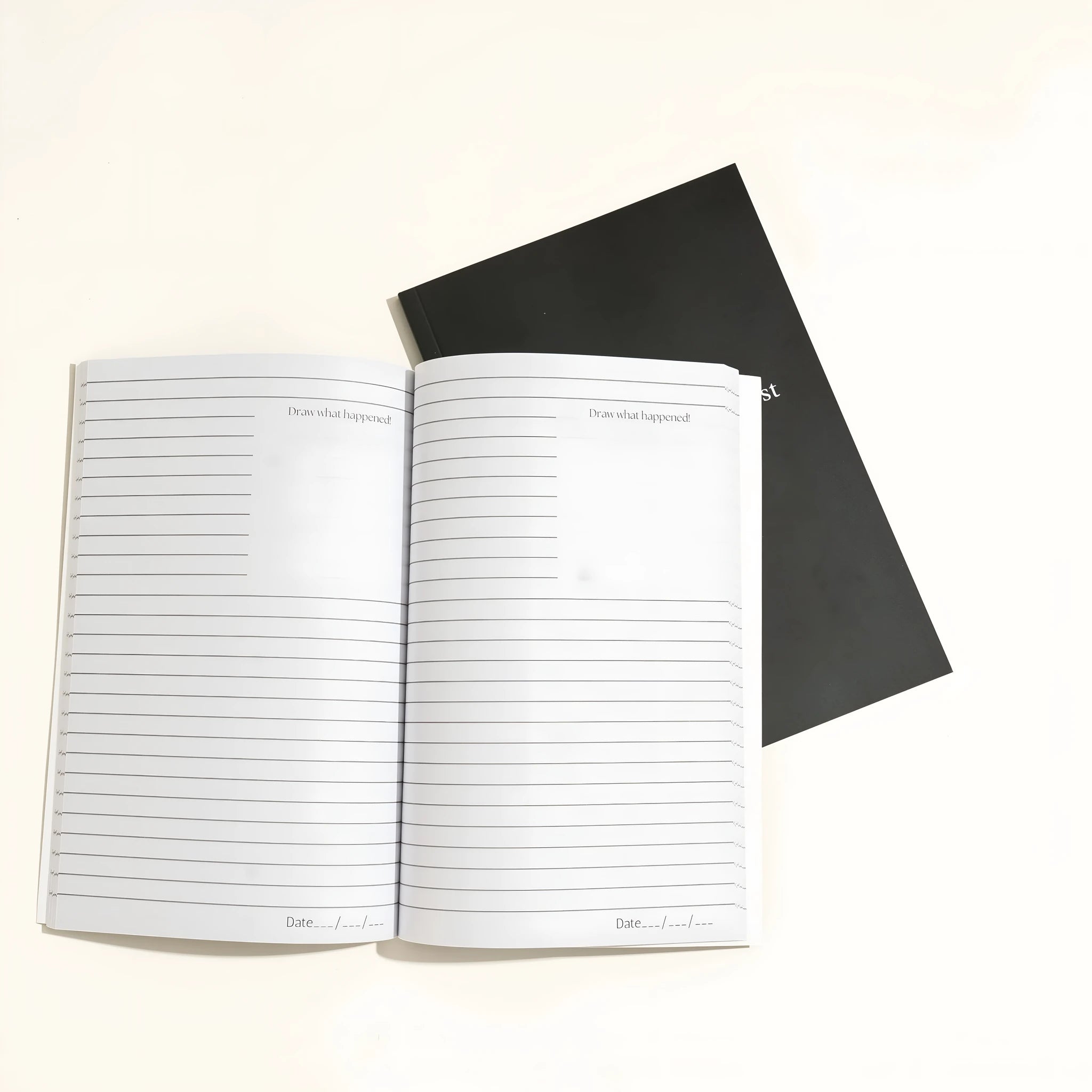 Black hardcover A5 dream journal notebook with plain pages, shown closed and open.