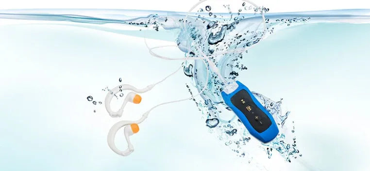 Compact black Bluetooth MP3 headset with USB cable, shown next to scale for size.