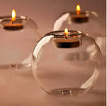 Clear handmade round hollow glass candleholder on a table.